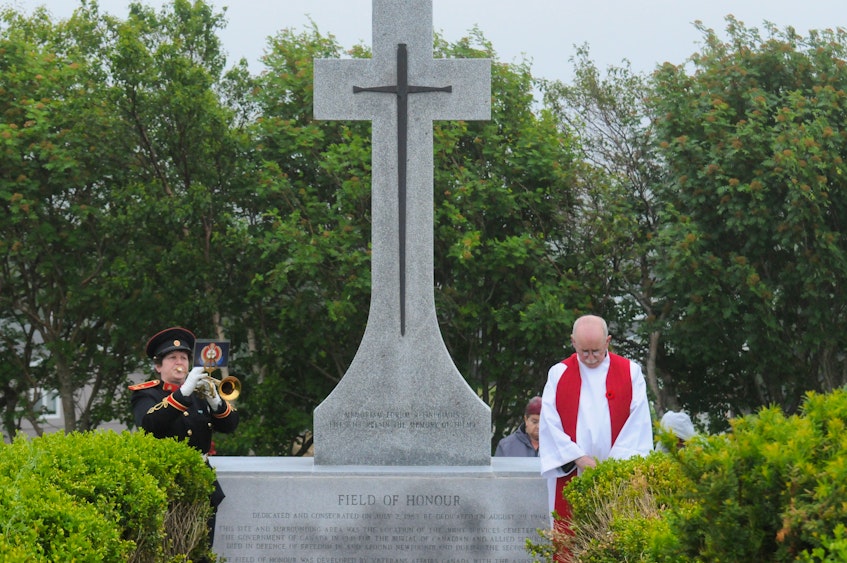 At the Royal Canadian Legion, Branch 1's Memorial Day ceremony at the Field of Honour on James Lane in St. John's, bugler Ruth Leake of the Church Lads Brigade band plays the "Last Post" and "Reveille." The Legion’s padre, Fr. Cecil Critch, is at the right — Joe Gibbons/The Telegram.