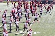  Calgary Stampeders players exercise and stretch near the end of the CFL team’s first training camp practice in Calgary on Saturday, July 10, 2021.