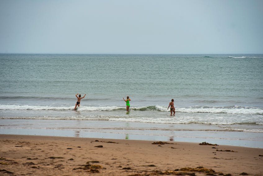 Visitors to Conrod's Beach play in the waves on Monday, July 12, 2021. Tropical Storm Elsa left behind conditions for powerful riptides. RCMP were called twice to the beach on Sunday for calls of swimmers caught in the riptide.