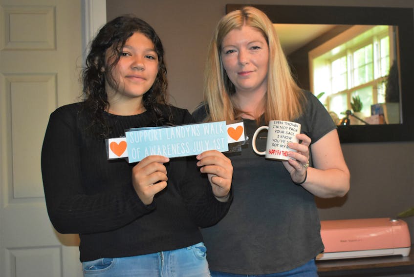 Twelve-year-old Emma and her mother Shannon hold up recent items they have created for their crafting lifestyle.