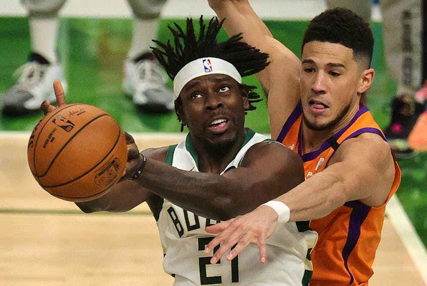 Jrue Holiday of the Milwaukee Bucks is defended by Devin Booker of the Phoenix Suns during the second half in Game 4  of the NBA Finals at Fiserv Forum on July 14, 2021 in Milwaukee, Wisc. 