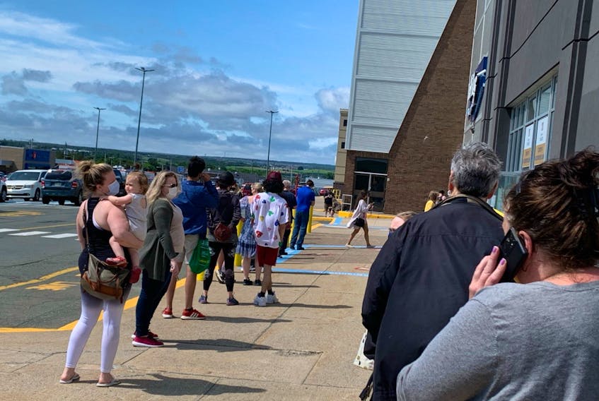 People were lined up outside the entrance to an Eastern Health COVID-19 vaccination clinic at the Village Shopping Centre in St. John' at lunchtime Friday. Eastern Health says a computer glitch led to delays in administration of vaccine doses. — Rosie Mullaley/SaltWire Network