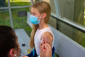 Annie Johns, 12, gets her first vaccine shot at a clinic on the Wanderers Grounds on Friday, July 16, 2021. The clinic was open to members of several local soccer clubs and adult leagues. The clinic continues on Saturday.