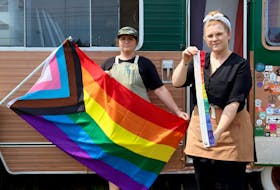 Christine Dickey, left, and Paige Heart were disappointed to find on July 16 that someone had cut down the Pride flag flying from their Holy Fox food truck in Cornwall. By 3 p.m., though, Pride P.E.I. had brought them a new flag. 