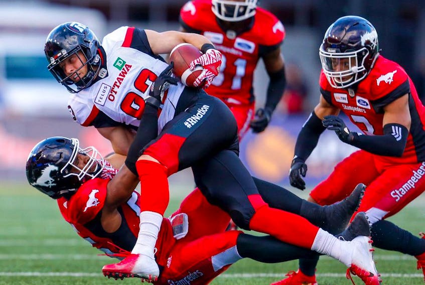 The Calgary Stampeders’ Jameer Thurman tackles the Ottawa Redblacks’ Greg Ellingson during a game at McMahon Stadium in Calgary on June 28, 2018. 