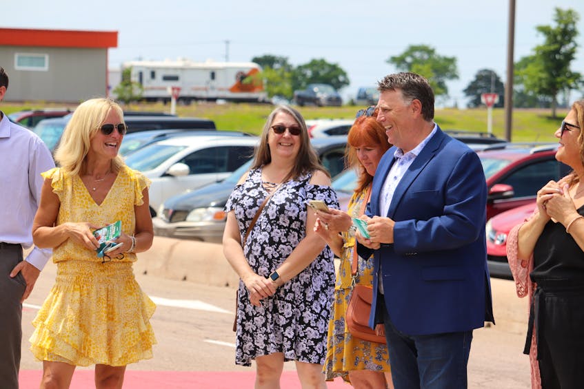 Chief Health Officer Dr. Heather Morrison, left, laughs with Premier Dennis King as they hand out Canada's Food Island gift cards as part of a tourism promotion and welcoming program.