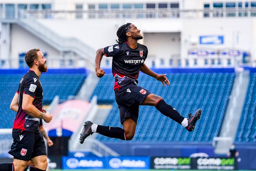 Ali Musse of Cavalry FC jumps in the air as he celebrates his second-half goal against HFX Wanderers as teammate Anthony Novak looks on in Canadian Premier League action Saturday in Winnipeg - CANADIAN PREMIER LEAGUE