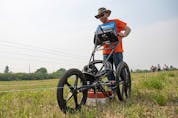  SNC-Lavalin engineer Evan Ulmer pushes the ground penetrating radar across a field in Delmas, Sask during a search for potential unmarked graves near the Delmas Indian Residential School site. Photo taken in Delmas, Sask. on Saturday, July 17, 2021.