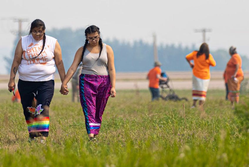  Storm and Lacy Night, whose grandparents attended the Delmas Indian residential school, hold hands as they walk across the ground where the search for potential unmarked graves begins. Photo taken in Delmas, SK on Saturday, July 17, 2021.