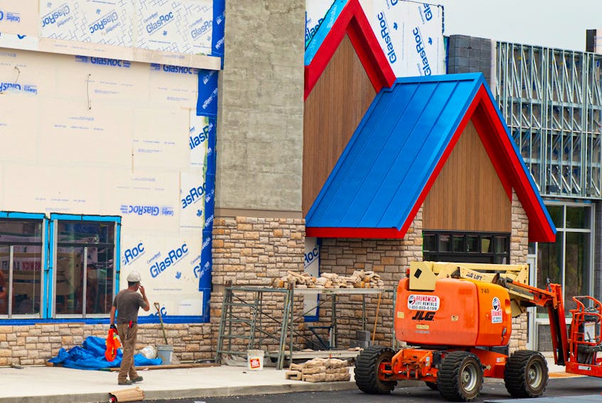 A construction worker walks past the building that will house the new IHOP in Bedford on Monday, July 19, 2021.