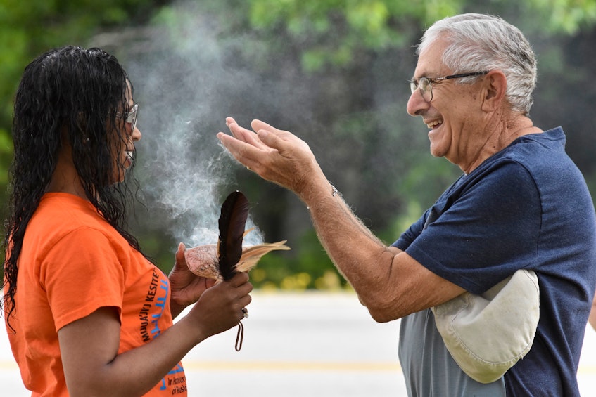 Brandy Jarvis-Nickerson of Acadia First Nation and Argyle Warden Danny Muise share a moment of happiness as the positive energy flowed during a smudging that took place between them and was also offered to other walk participants. TINA COMEAU PHOTO - Tina Comeau