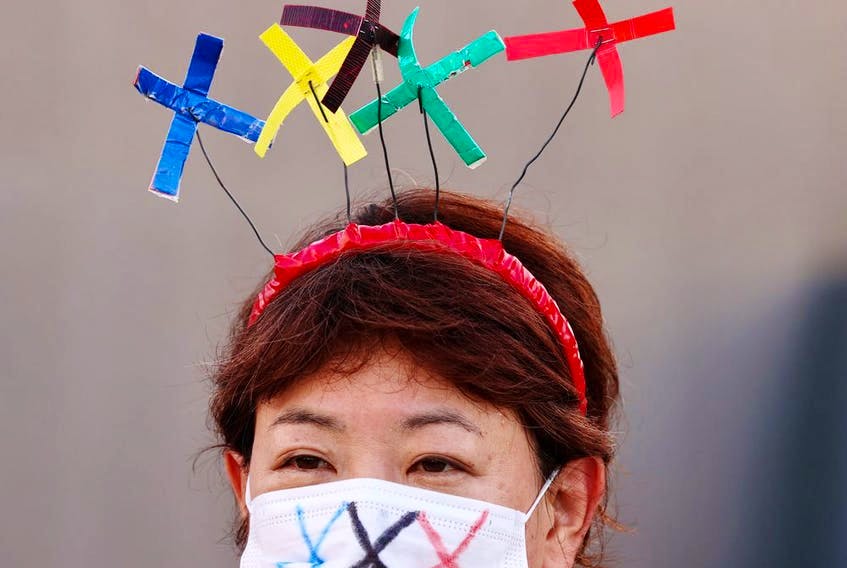 A protester wear a protective face mask during a rally near Akasaka State Guest house where International Olympic Committee (IOC) president Thomas Bach attended a welcome ceremony. - Postmedia  photo