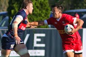 Canada's Nathan Hiramaya (10) straight-arms a USA player during International rugby match action between Canada (red) and USA (blue) at Twin Elm Rugby Park in Nepean (Ottawa) this afternoon, Saturday, August 22, 2015. Canada vs. USA. International Rugby. Twin Elm Rugby Park.