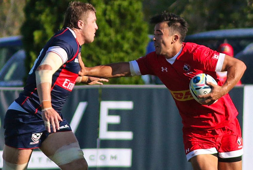 Canada's Nathan Hiramaya (10) straight-arms a USA player during International rugby match action between Canada (red) and USA (blue) at Twin Elm Rugby Park in Nepean (Ottawa) this afternoon, Saturday, August 22, 2015. Canada vs. USA. International Rugby. Twin Elm Rugby Park.