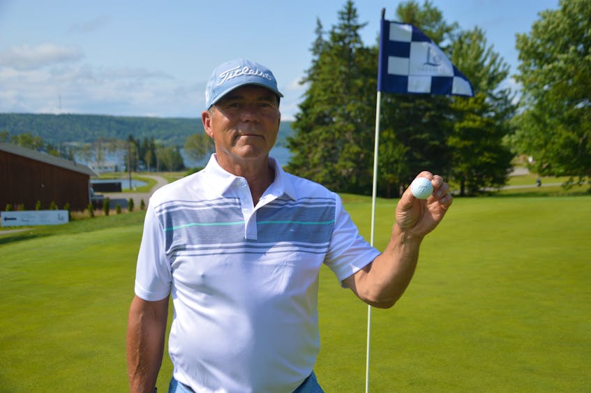 Martin Burke is shown holding a ball in front of the No. 18 hole at The Lakes Golf Club in Ben Eoin on Tuesday. The Sydney golfer hit a rare albatross with the ball during a round of golf at the course last month. JEREMY FRASER/CAPE BRETON POST