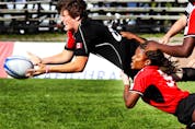  Britt Benn of Team Canada (in Black) throws the ball as she’s tackled by Team Trinidad and Tobago (in Red), during the North American Caribbean Rugby Association qualifying tournament for Moscos Cup, held at Twin Elm Rugby Park, in Ottawa, on, on August 27, 2012. Team Canada won 46-0.