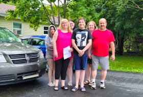 Resume in hand, job-hunter Lori Delaney is ready to take the family minivan and head back to work after 21 years of raising her family with her husband, Keith Delaney. Her children, from left, Hannah, Abby, Riley, and Casey, as well as daughter Mia - who is not in the photograph - support their mother. 
