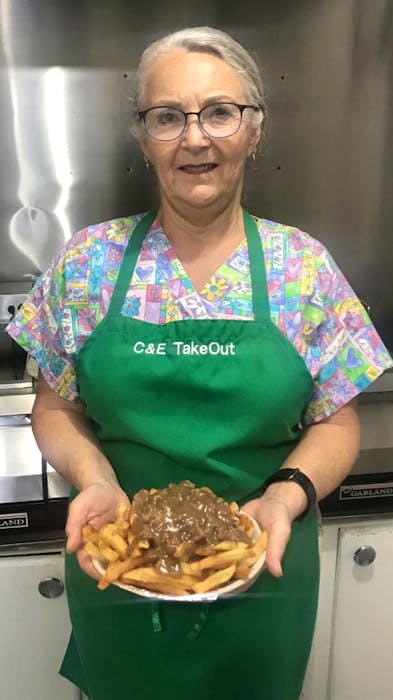 Cindy Batt, one of the co-owners of C and E Takeout in Mount Moriah, N.L., shows off the little take-out's famed hamburger meat, fries and gravy dish. The fry dish has been popular with locals for four decades.