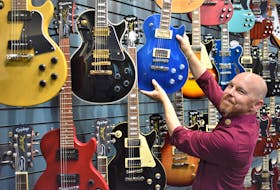 Truro’s Long and McQuade Musical Instruments manager Tony Bouma by the large guitar display in the new store.