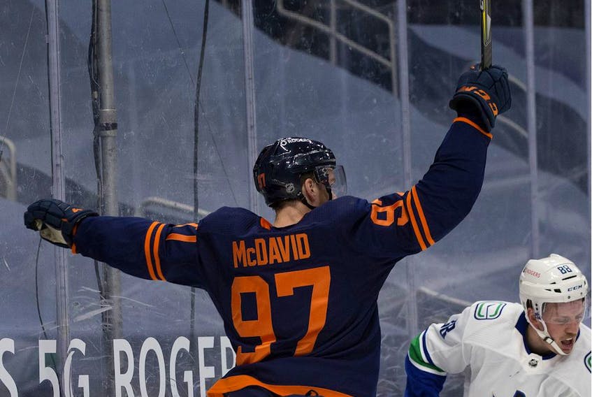 The Edmonton Oilers' Connor McDavid (97) celebrates the Oilers' second goal against the Vancouver Canucks during first period NHL action, in Edmonton Thursday Jan. 14, 2021. 