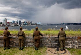 Tour guides with the Halifax Citadel Society dressed in Second World War military uniforms watch a rolling thunderstorm pass between Halifax and Dartmouth on Friday.

TIM KROCHAK PHOTO