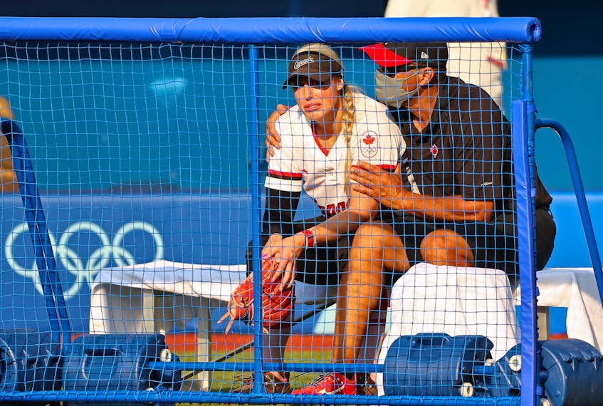 Canadian coach Mark Smith, of Falmouth, consoles pitcher Danielle Lawrie after a heart-breaking 1-0 loss to Japan at the Tokyo Olympics.  - Jorge Silva / Reuters