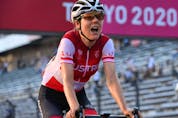  Austria’s Anna Kiesenhofer, the actual gold medal winner, celebrates after crossing the finish line to win the women’s cycling road race of the Tokyo 2020 Olympic Games.(Photo by Greg Baker / AFP)