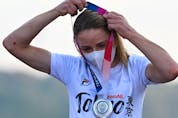  Silver medallist Netherlands’ Annemiek Van Vleuten puts on her medal. (Photo by Greg Baker / AFP)