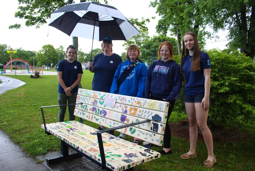 Summerside Girl Guide leader Pauline Dicy, second from left, and members Robyn Lough, Brianna Baglole, Madalyn Cornish and Phoebe MacLean stand next to one of the benches painted in the project. This bench, which went up in Leger Park, was painted by the Grandparents Group of Summerside and their grandchildren.