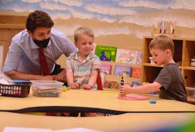 Prime Minister Justin Trudeau watches Mattéo, centre, and Henry play with some Play-Doh and toys July 27 at the Carrefour de l’Isle-Saint-Jean in Charlottetown. The prime minister was in town for a joint federal-provincial government announcement that will see an average of $10 a day early learning and child care in P.E.I. in three years.