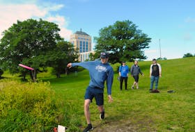 Cameron Hickman tees off at St. John's first disc golf tournament last weekend, as (from left to right) Kris Moulton, Riley Brooks and Mike Fardy look on.