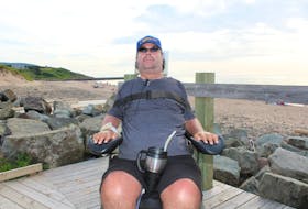 In this 2018 file photo, Callum MacQuarrie sits in his motorized wheelchair on the boardwalk at Inverness beach. In the background is the breakwater where he broke his neck in a 1995 diving accident. As co-chair of the Inverness County Accessibility Committee, he helped make Inverness beach the most accessible beach in Atlantic Canada. Chris Connors • Cape Breton Post