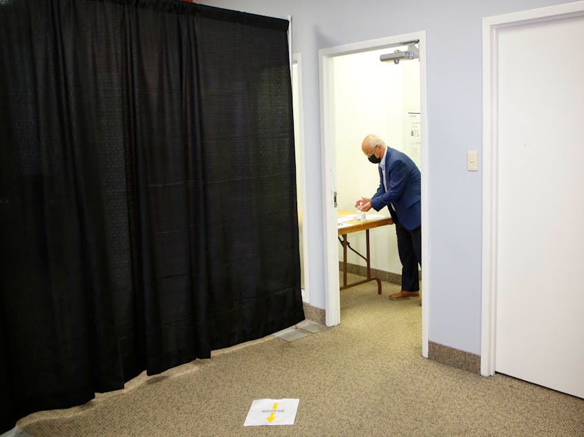 N.S. NDP Leader Gary Burrill sanitizes his hands before casting his early ballot at a returning centre in Halifax on Wednesday, July 28, 2021. - Tim Krochak