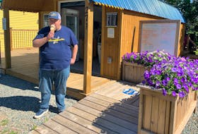 Daniel Curren tucks into a cone of candy cane ice cream outside his Tatamagouche Ice Creamery shop, which is doing a thriving business on the village's main street.