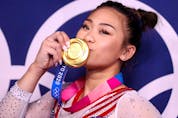  Gold medallist Sunisa Lee of the United States kisses her medal.