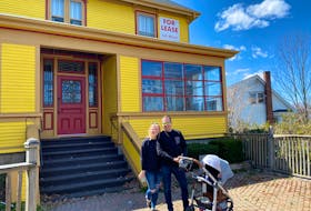 Colette O’Hara, Ezra Edelstein and their son in front of The August House. 