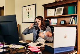 Cape Breton Mayor Amanda McDougall and baby Emmett both grab a drink in her office in Cape Breton Regional Municipality.