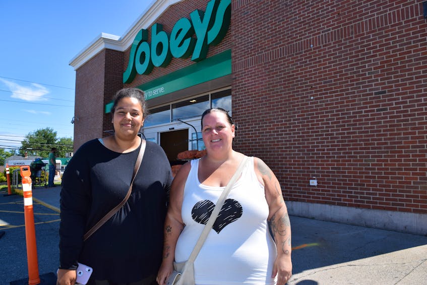 Dominique Ryan, 21, left, of New Waterford and her mother Dawn Ryan, in front of the Sobeys in Scotchtown, Wednesday. Dominique credits the support of her Facebook group 'An act of kindness’ for allowing them to stand at the cash registers and pay for $2,500 worth of groceries as customers went through the registers. Sharon Montgomery-Dupe