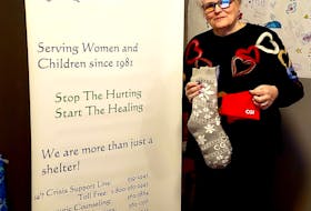 Helen Morrison, the now-retired executive director of Cape Breton Transition House, stands by a sign promoting the organization in this photo from February. CONTRIBUTED/FACEBOOK 