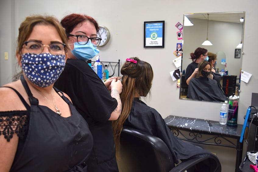 Tracy Wood, left, and Jessica Elliott, hairstylists at Scissor Haven Salon and Barber Shop, are happy to once again be greeting clients such as Angelina Gouchie who believes the hair industry should be considered an essential service because of the mental health benefits it offers. Harry Sullivan 