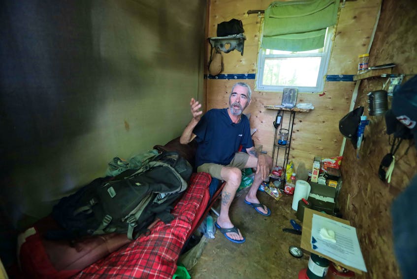 Inside Allan DeYoung’s temporary shelter is a cot with a sleeping bag on top, a shelf and a camping stove he uses to cook with, among other small items.