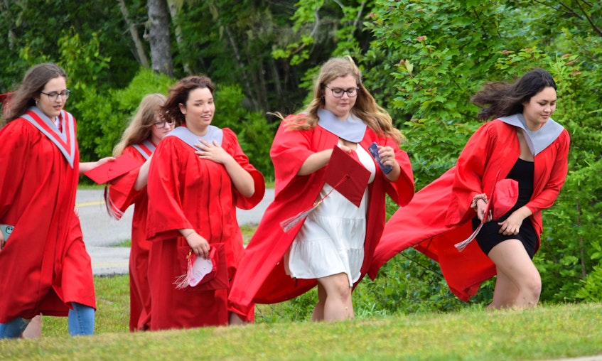 A group of BMHS graduates walk together across the school grounds prior to the community drive-by celebration parade on June 27. KATHY JOHNSON - Kathy Johnson