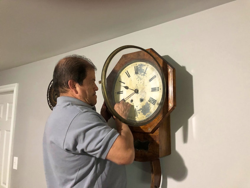 One of Alberto Cardona’s oldest clocks is this wall clock, which dates back to about 1860. While there are some imperfections due to age, the vintage piece still works, as Cardona demonstrates. - David MacDonald