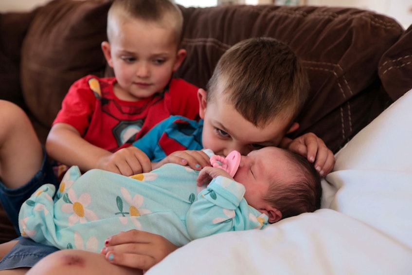 Brothers Noah, 5, and Sawyer, 3, cuddle their new sister Annabelle at their Lawrencetown area home Thursday, July 8, 2021. - Eric Wynne