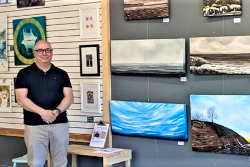 Artist Stéphane Richard stands next to some of his paintings displayed during an art exhibit he held at the 7Arts Community Art Centre in Greenwood this June. Richard has been teaching art at the high school level in the Valley for over 20 years. 