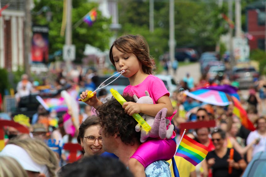 Ella Soleil, 5, blows bubbles during the Annapolis Royal Pride walk on Aug. 7 from the shoulders of her father Kai Lehrke. - Jason Malloy