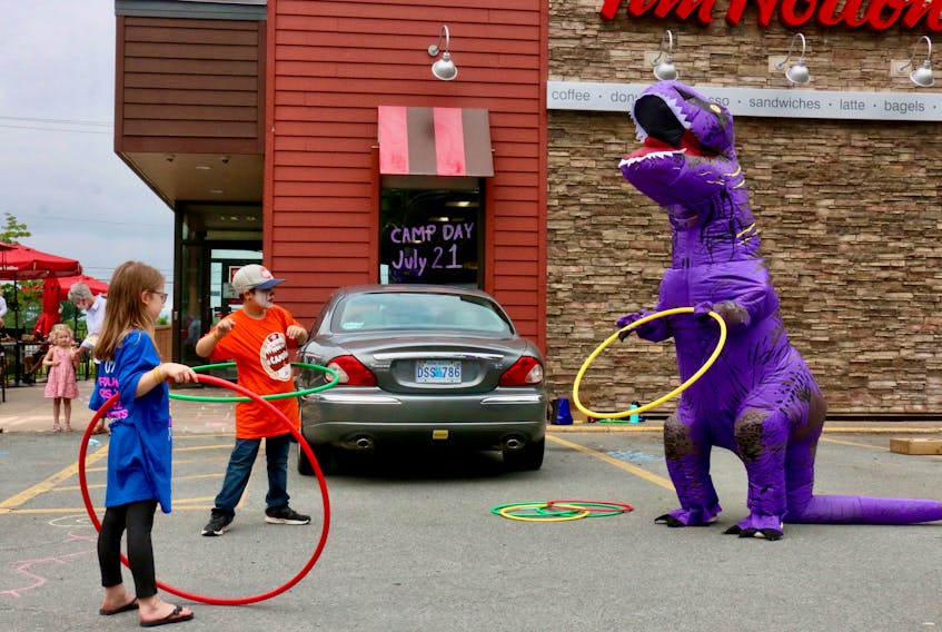 Amaya Hazel, 7, and Jayden States, 9, were among the children trying to help West Hants Recreation’s dinosaur learn how to hula hoop during a Camp Day fundraiser outside Tim Hortons.