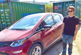 Phil Rideout bought the first electric car to make its way to the north coast of Labrador for his stepson, Trevor, pictured with the Chevrolet Bolt. In the background is a container they modified with solar panels, an inverter and batteries to charge the car using sunlight.