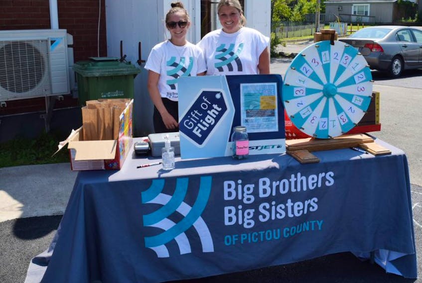 Sarah MacNeil and Sophia Wornell helped out with a raffle as part of a barbecue at the Big Brother Big Sisters of Pictou County in New Glasgow.