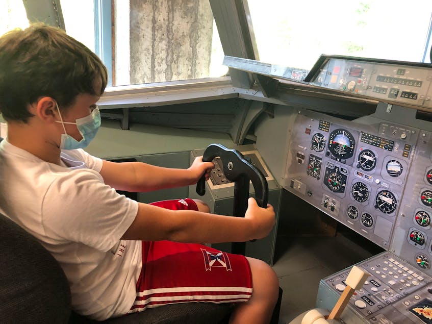 Seven-year-old Michael Barker pretends to be a pilot at the controls of the BAE 146 at the Atlantic Canada Aviation Museum. - Helen Earley